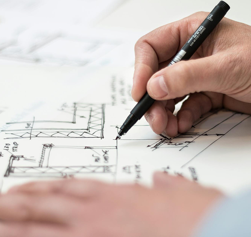 Person sketching architectural designs with a pen on paper